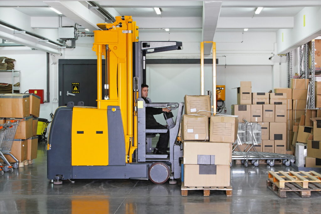 Electric forklift stacker in warehouse with boxes
